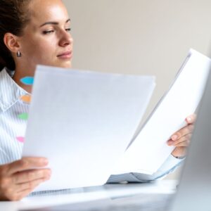 a woman reading papers at a desk