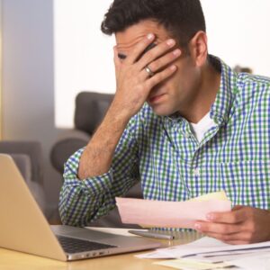 frustrated man looking over financial documents